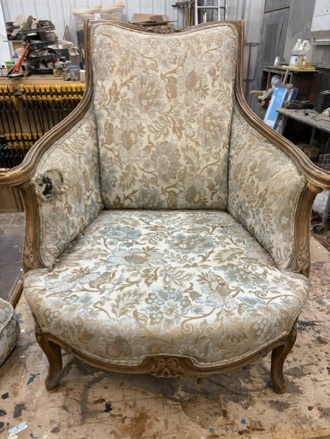 Antique armchair with worn floral upholstery before restoration